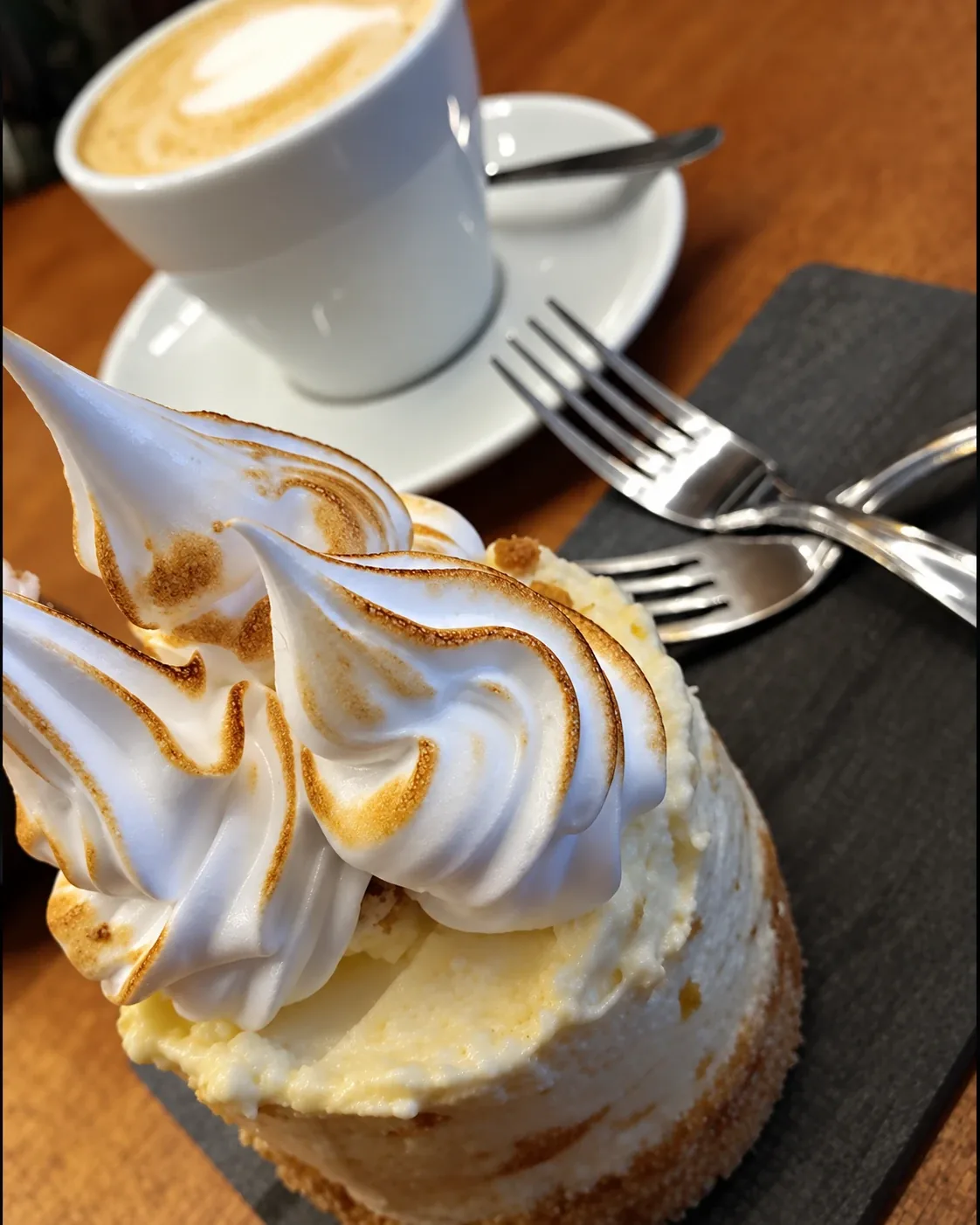 Una porción de lemon pie con un café