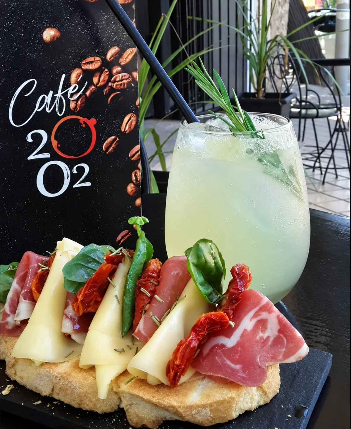 Un tostón de jamón crudo, queso y tomates secos, con una limonada